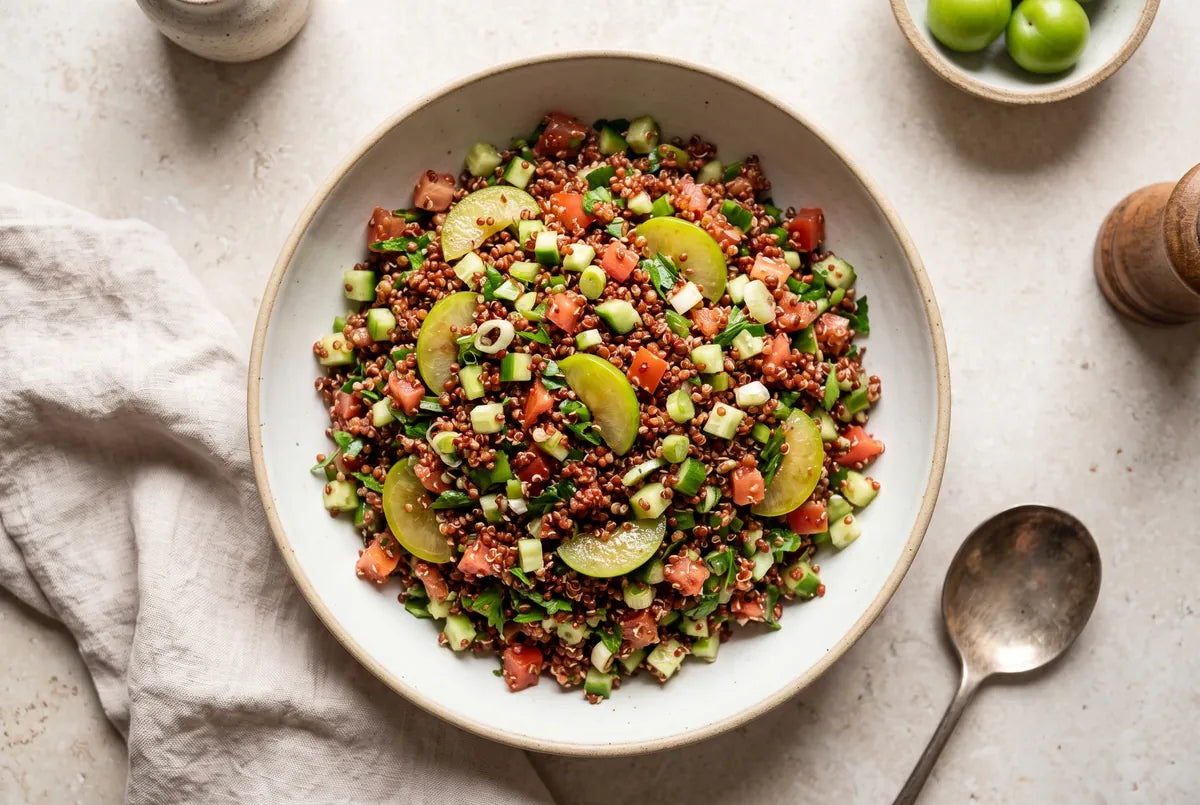 Gluten-free kisir built on red quinoa and brightened with tart green plums.